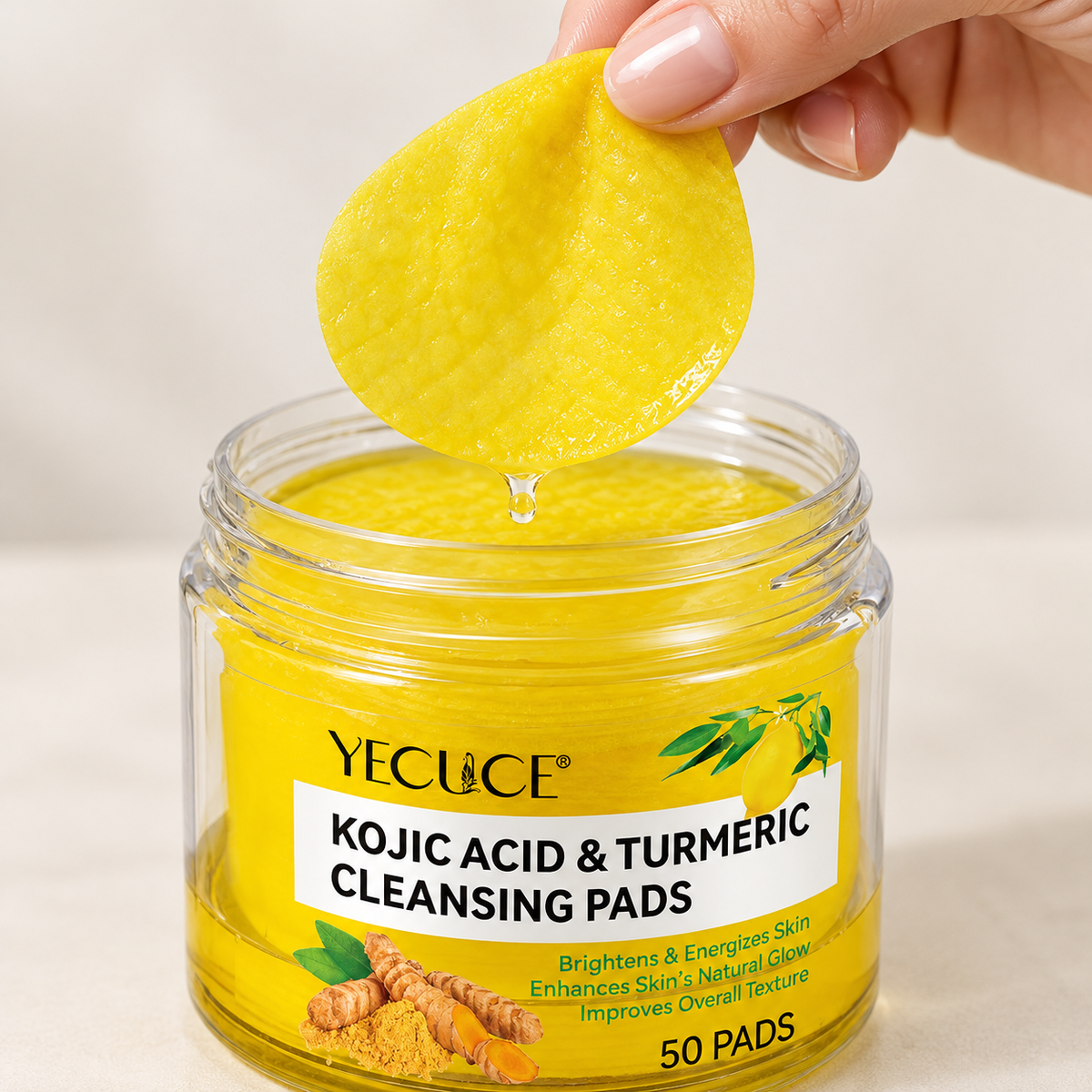 A yellow pre-soaked cleansing pad lifted from its jar